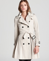 A classic style gets a luxurious lift with this fur-trimmed Burberry London trench coat, designed with a pleated skirt, belted details and the designer's signature check lining. The piece to complete your capsule collection, this wardrobe is a fashion must.