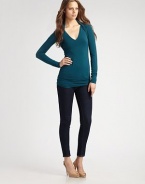 Body-skimming stretch knit, finished with layered shrug shoulders.V neckline Long sleeves Ruched back panels About 28 from shoulder to hem 94% rayon/6% spandex Dry clean Made in USA