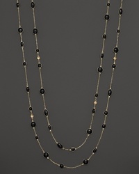 Round and oval grey enamel stations and a diamond highlight this gold chain necklace.