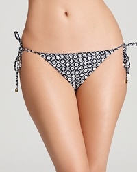 Perfect to lighten up your getaway bag, Tory Burch's two-for-one reversible bikini bottom showcases a white floral print in subdued navy on one side, playfully sunny yellow on the other. Mix it up.