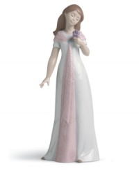 Forever elegant. This handmade porcelain figurine presents a young woman in fresh white and pink with carved floral detailing, sure to make a lasting, graceful statement in any home.