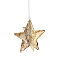 Formed of sparkling Swarovski crystal in a warm golden hue, this star-shaped ornament shines in bold dimension.