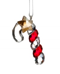 Shiny and sweet, the Swarovksi crystal candy cane ornament features ribbons of holiday red and a dangling gold star.