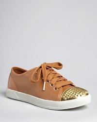 MICHAEL Michael Kors puts a signature spin on the cap toe sneaker, pairing smooth leather with bold, studded gold.