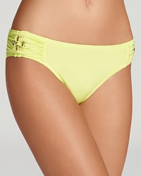 Brilliant color and retro-right goldtone hardware define a deceptively simple bikini bottom from designer Trina Turk.