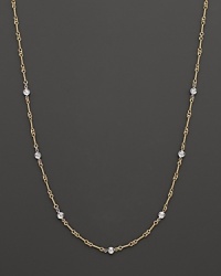 A yellow and white gold necklace with bezel-set diamond stations. With signature ruby accent. Designed by Roberto Coin.